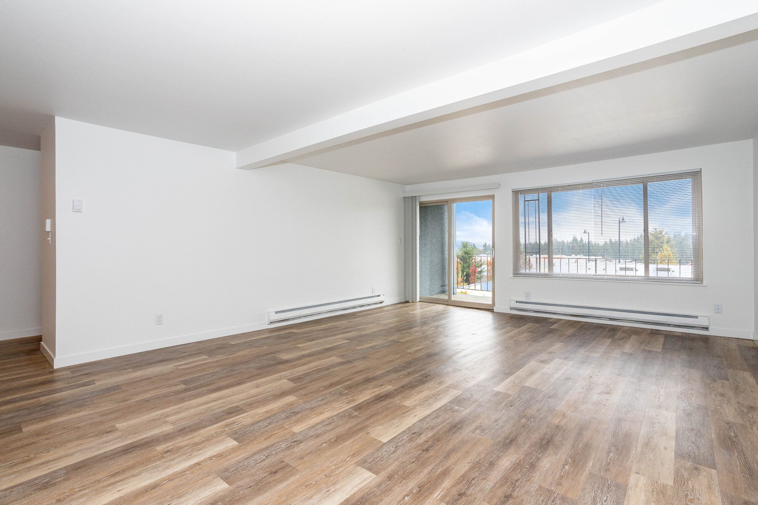 Studios in Shoreline WA - Octavia - Living Room Area with Wood Floors, Window, and Balcony Access